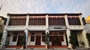 A two-story boutique hotel with a traditional architectural style, featuring wooden shutters and a prominent signboard. - Mclane Boutique Hotel (George Town)