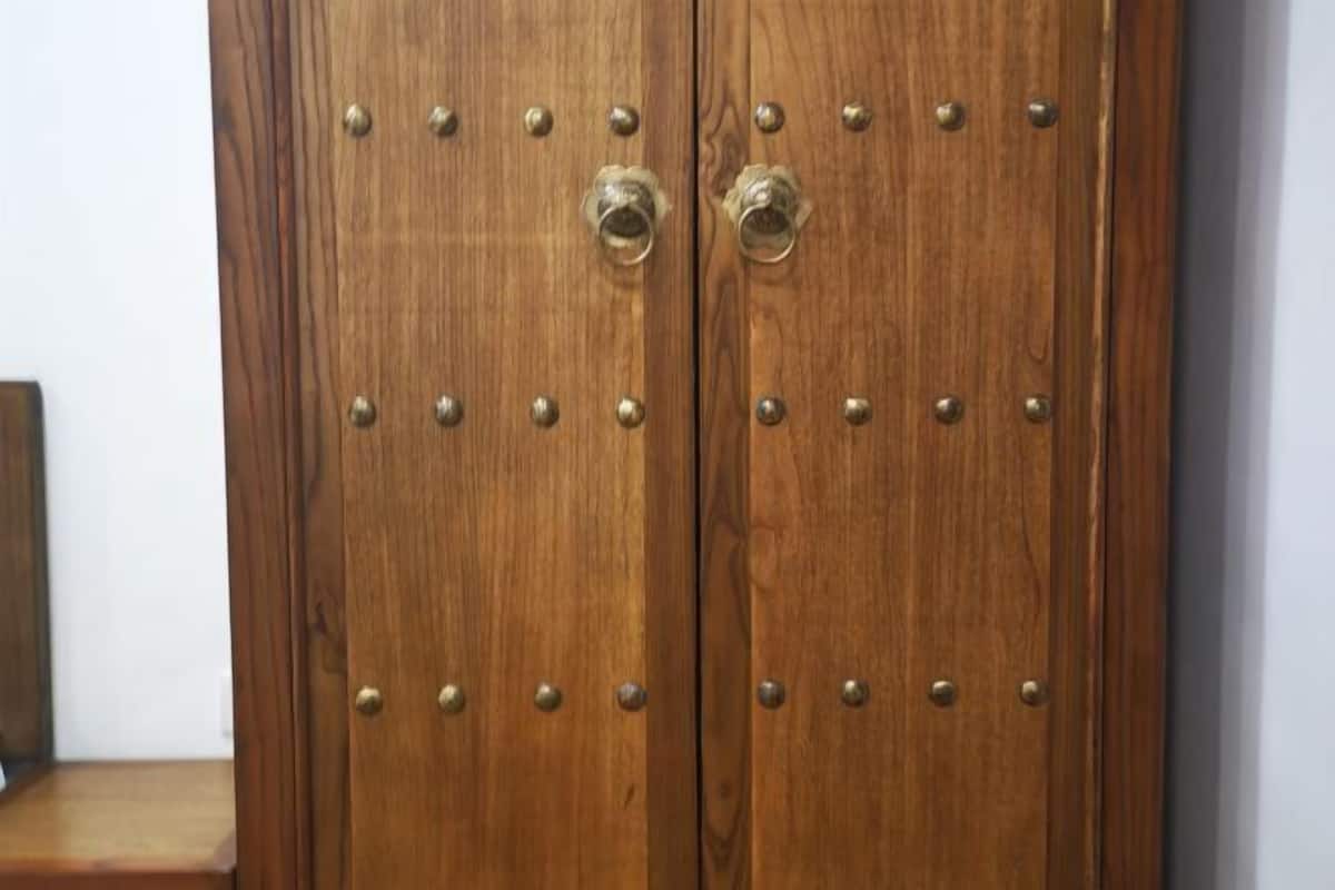 Eine Holztür mit Metallnieten und zwei runden Griffen.