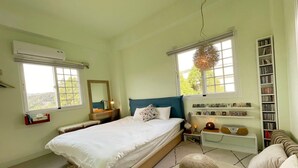 A bedroom with a bed, bedside tables, a bookshelf, and a window with a view of greenery. - Read Nice House (Wujie)
