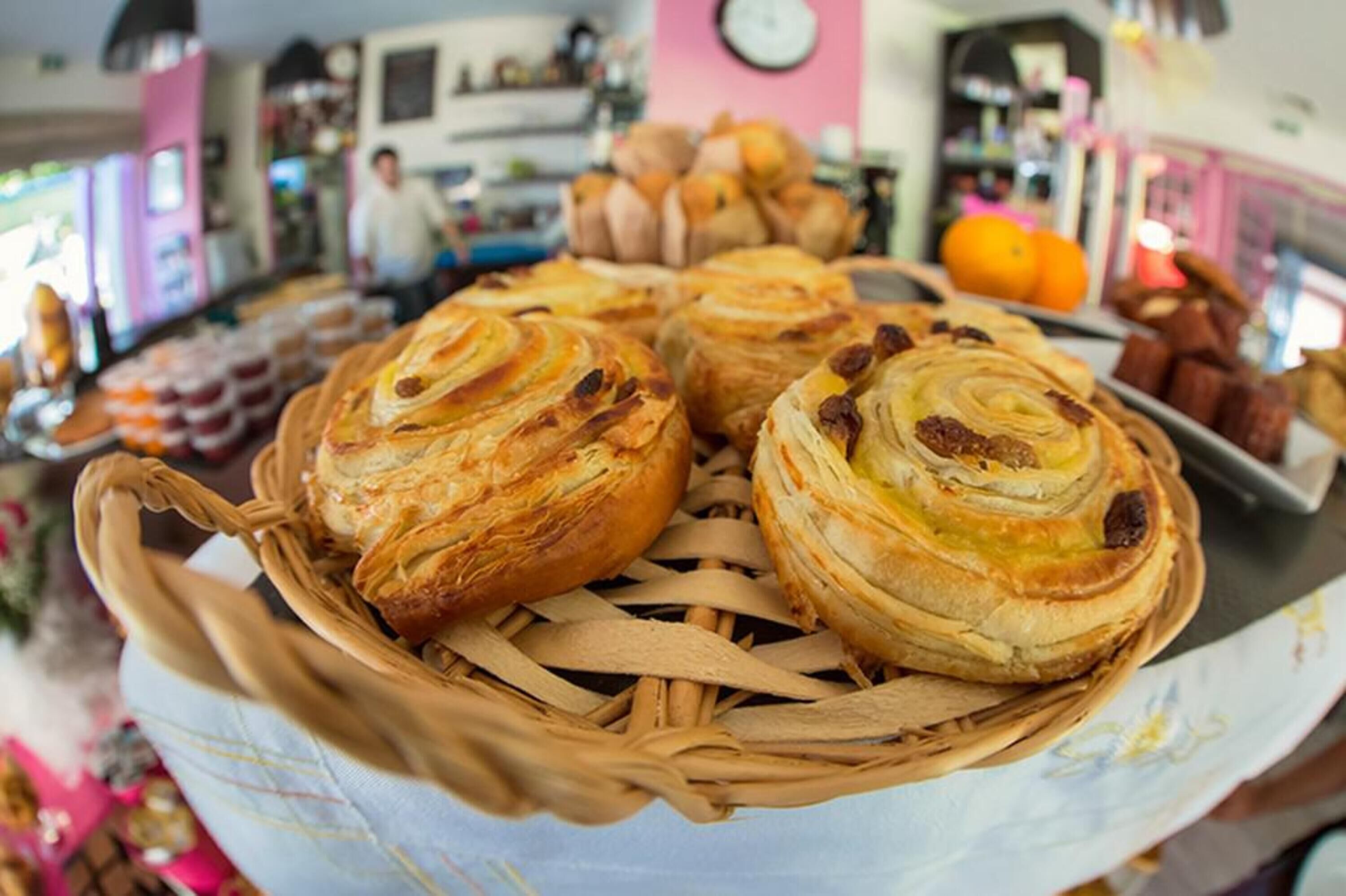 A basket of pastries on a table in a cafe setting.