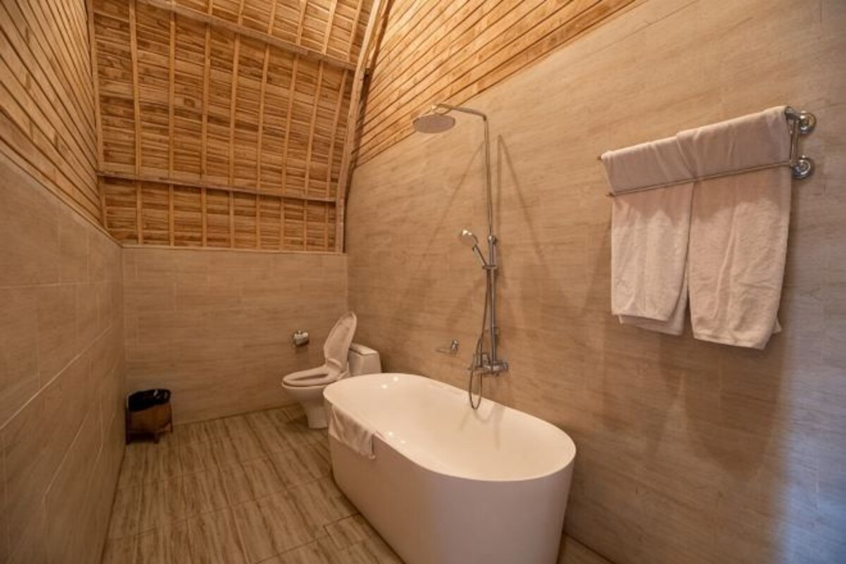 Un baño con bañera, inodoro y ducha.