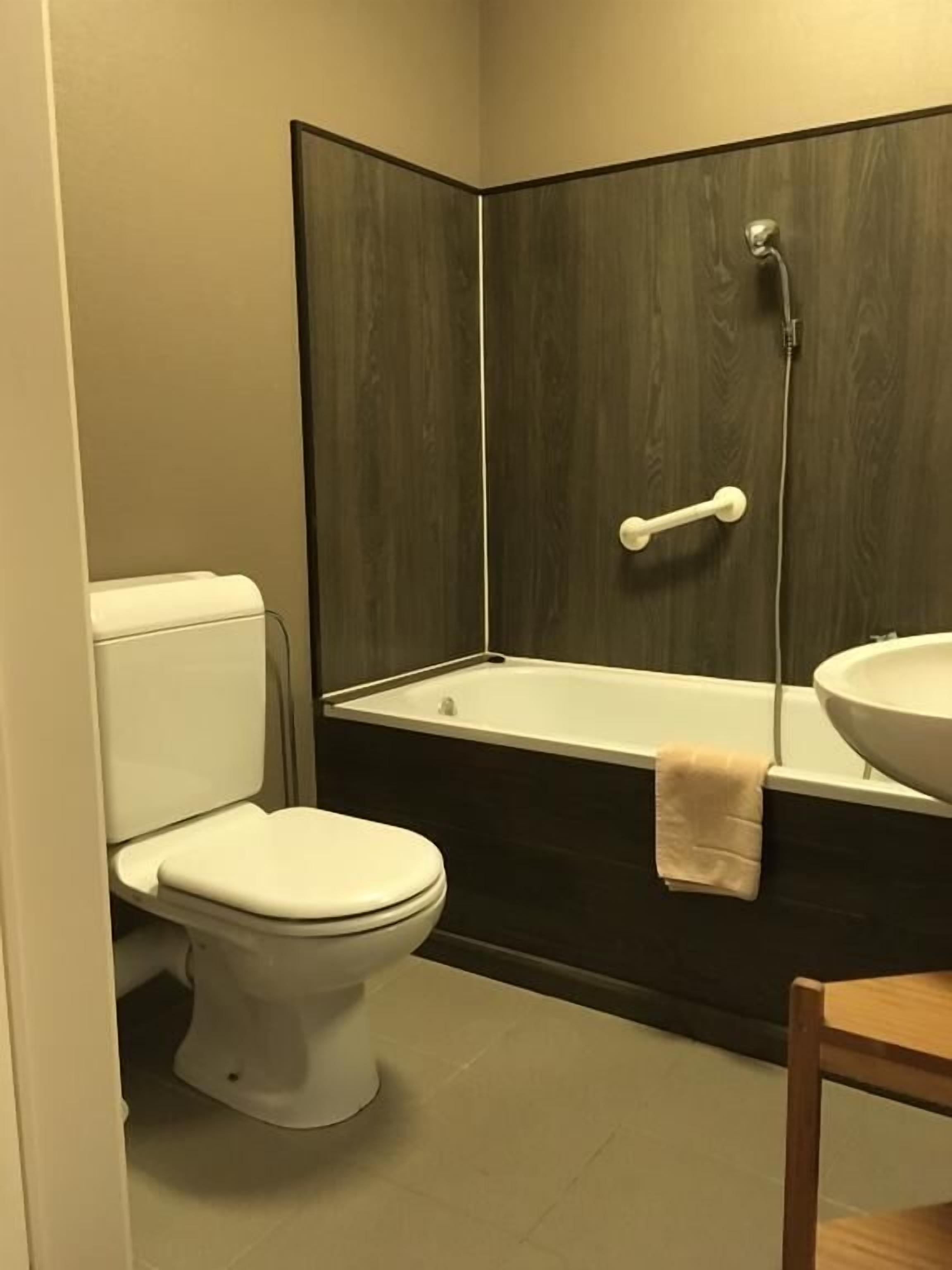 Un baño con inodoro, bañera y lavamanos.