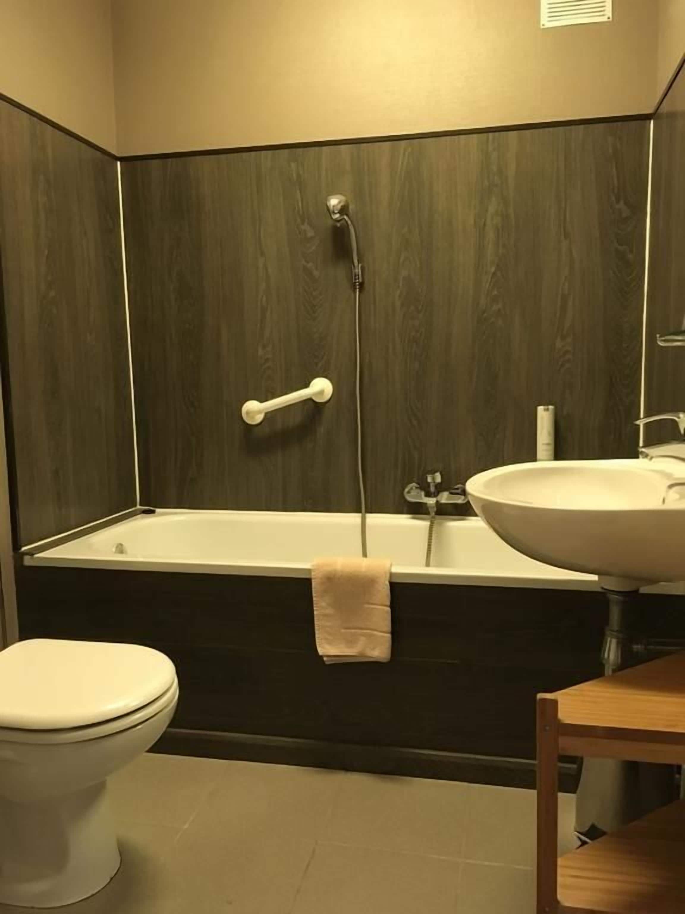 Une salle de bain avec une baignoire, des toilettes et un lavabo.