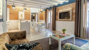A modern living room with a fireplace, a dining area, and a kitchen in the background. - Enjoybcn Colon Apartments (Barcelona)