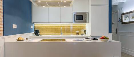 A modern kitchen with a central island, stainless steel appliances, and a unique yellow patterned backsplash.