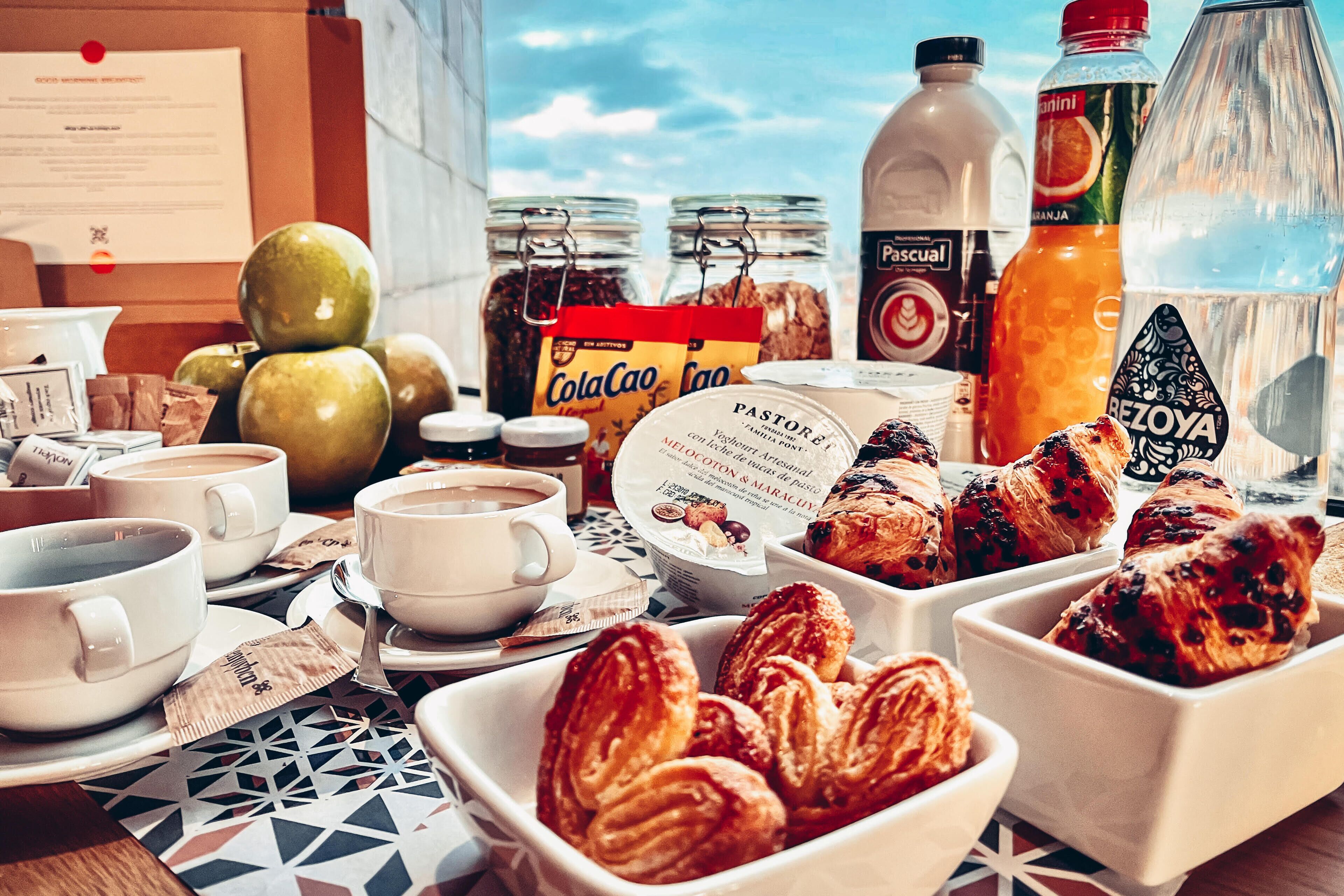 Desayuno con bollos, café y aderezos.