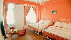 Ein Zimmer mit zwei Betten, einem kleinen Tisch, einem Stuhl und einem Fenster mit Vorhängen.