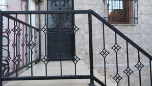 A staircase with a black metal railing leading to a door with decorative metalwork. - Istanberry - Dream Apartments (Istanbul)