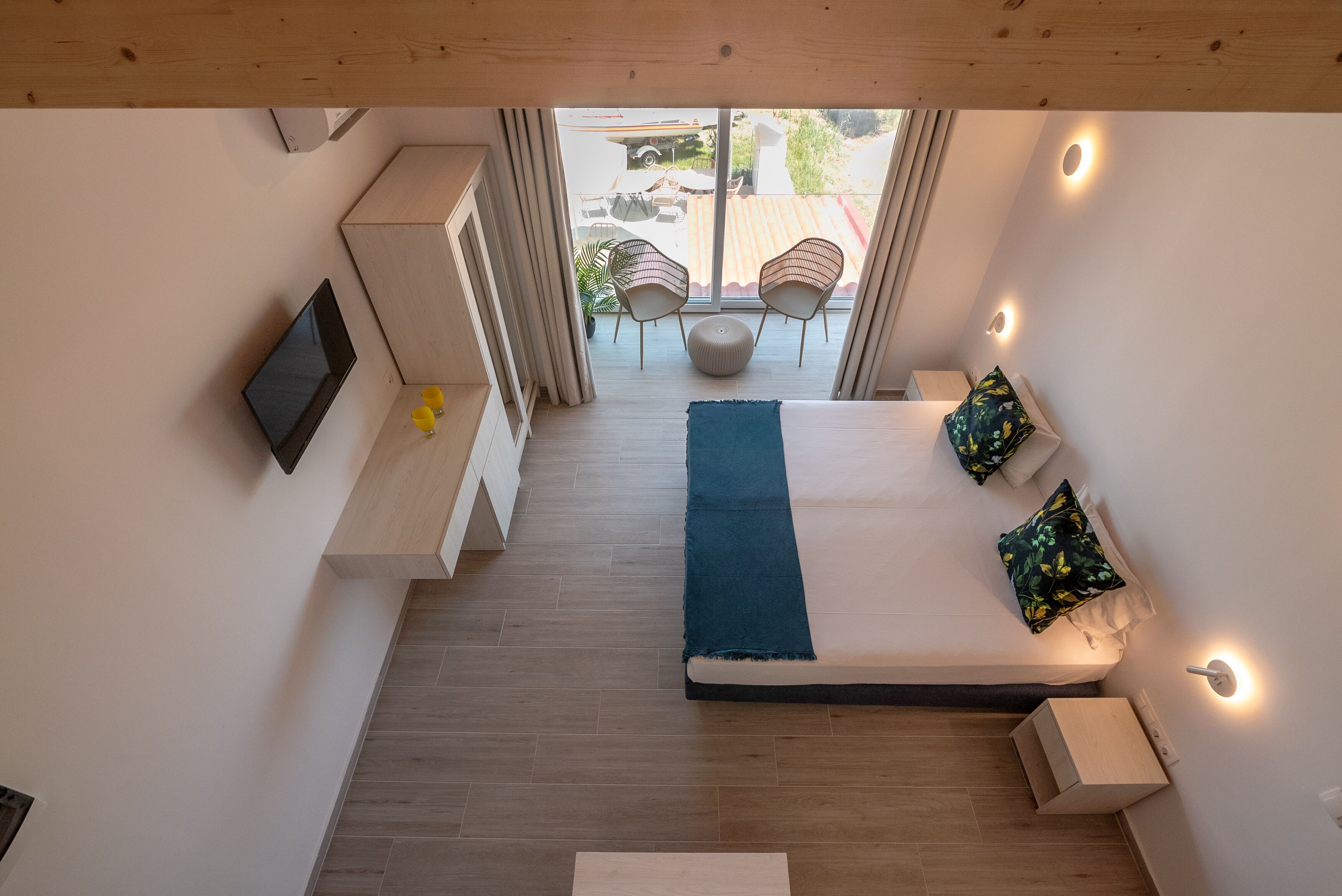 Camera da letto con un letto, una TV, un tavolino e una finestra vista esterna.
