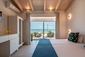 A bedroom with a bed, a desk, and a view of the sea. - GT Beach Hotel (Platanias)