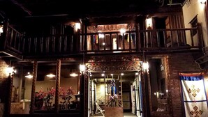 Un edificio tradicional con un balcón de madera y una entrada central.