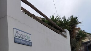 Una pared blanca con un letrero que dice "Absolute Matala" y una dirección de correo electrónico.