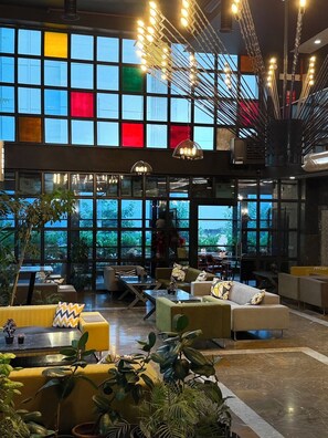A spacious lobby with large windows, multiple seating areas, and hanging light fixtures. - Mugwort Hotel&Spa (Istanbul)
