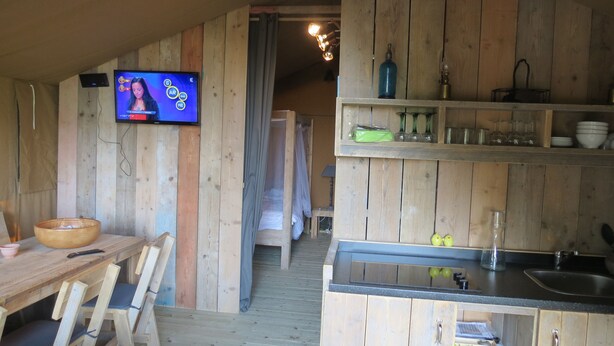 A rustic wooden interior with a dining area, a television, and a kitchenette. - Domaine du Siestou Wine Resort & Spa (Laure-Minervois)