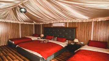 Ein Zimmer mit einem großen Bett, einem Nachttisch und einer Pendelleuchte.