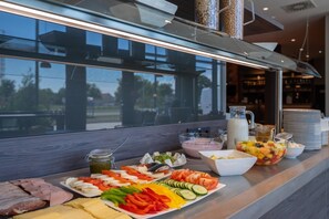 A buffet with various food items including meats, cheeses, fruits, and vegetables. - Campanile Vienna South (Vienna)