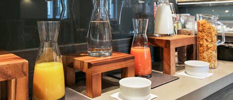 Una barra de desayuno con diversas bebidas y alimentos.
