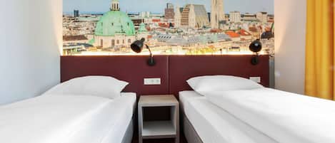 A hotel room with two single beds, a small nightstand, and a cityscape view through a window.