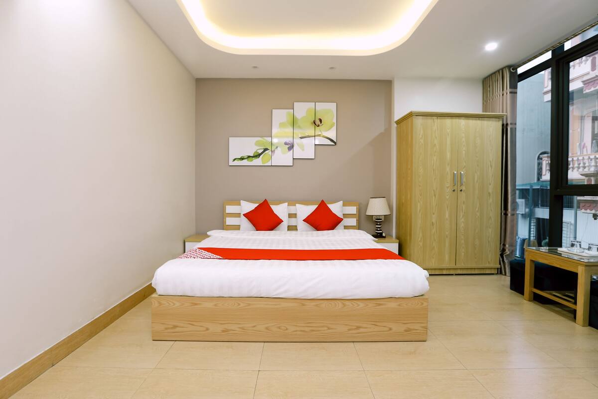 Een slaapkamer met een bed, een kledingkast en een nachtkastje.
