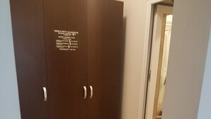 A room with a large wardrobe, a patterned rug, and a window. - Casa Stefan Galati (Galati)