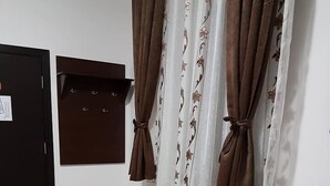 A room with a black table, two chairs, a radiator, and brown curtains. - Casa Stefan Galati (Galati)