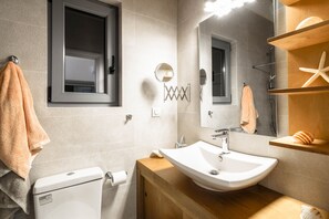 Un bagno moderno con servizi igienici, lavandino e specchio.