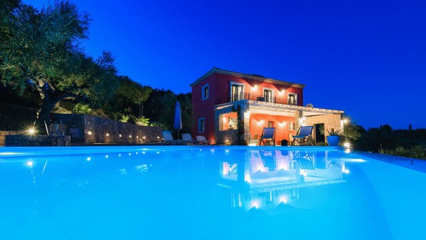 Uma piscina grande com uma casa ao fundo.