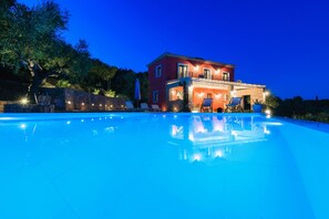 Uma piscina grande com uma casa ao fundo.