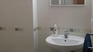 A bathroom with a sink, mirror, and toilet. - Noja Rooms (O Pino)