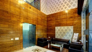 Un interior moderno con paneles de madera, una puerta de vidrio, asientos de cuero y una alfombra estampada.