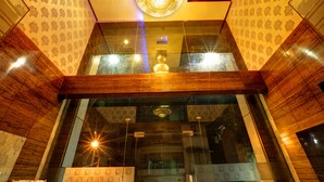 Un interior moderno con techo de madera, papel tapiz estampado y un candelabro central.
