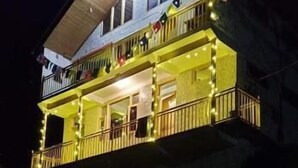 Un edificio de dos pisos con balcones y luces colgantes.
