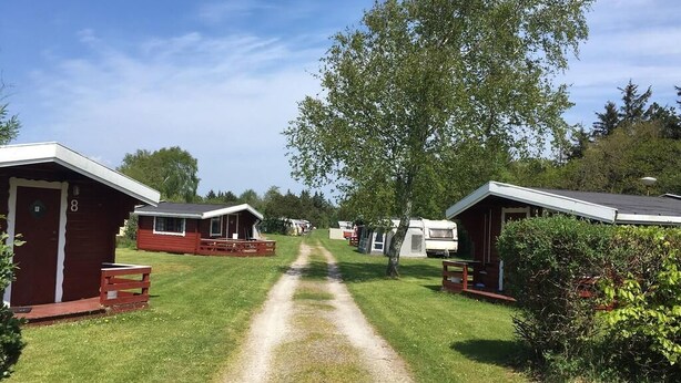 A campsite with RVs and mobile homes, a gravel path, and trees. - Bygholm Camping Thy (Vesløs)