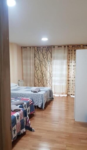A room with two beds, a radiator, and a wooden floor. - Javier Pedrouzo Sleeping Group (O Pino)