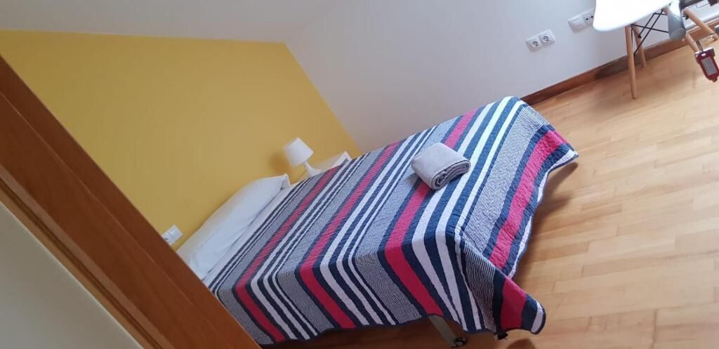 A small room with a bed, a chair, and a desk.