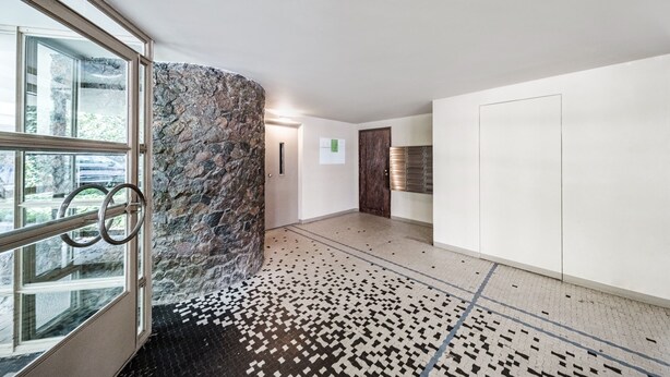 A modern interior with a stone accent wall, a patterned floor, and a glass door leading outside. - Friends Avenue Apartment (Warsaw)