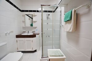 Regadera, secadora de cabello, toallas, papel de baño 