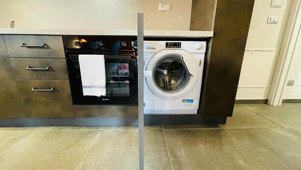 A kitchen with a built-in oven and a front-loading washing machine. - VILLA LINDA - Studio  sleeps 2-3 (Bardonecchia)