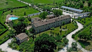 An aerial view of a property with a large building, a swimming pool, and solar panels. - La Fonte di Montebuono (Magione)