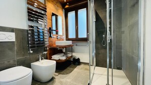A modern bathroom with a glass-enclosed shower, a white sink, and a bidet. - Villa Linda - STUDIO sleeps 4 (Bardonecchia)
