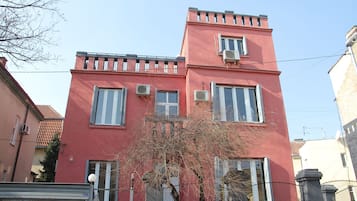 Un bâtiment rouge doté de nombreuses fenêtres et de plusieurs unités de climatisation.