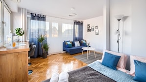 Uma sala de estar moderna com um sofá, uma mesa de centro e uma escrivaninha com uma planta.