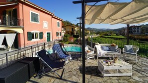 A terrace with outdoor seating, a pool, and a view of the surrounding landscape. - Villa Perla by VILLASRETREATS w/Pool, A/C, WiFi, BBQ near 5 Terre (Pignone (La Spezia))