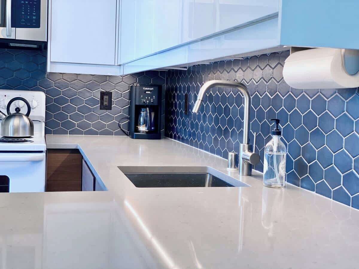 A modern kitchen with a stainless steel sink, a coffee maker, and a water dispenser.