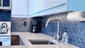A modern kitchen with a stainless steel sink, a coffee maker, and a water dispenser. - Mod Downtown Escape, Pool, Spa, Tennis, Pickleball (Palm Springs)