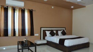 Quarto com cama, mesa de cabeceira e criado-mudo.