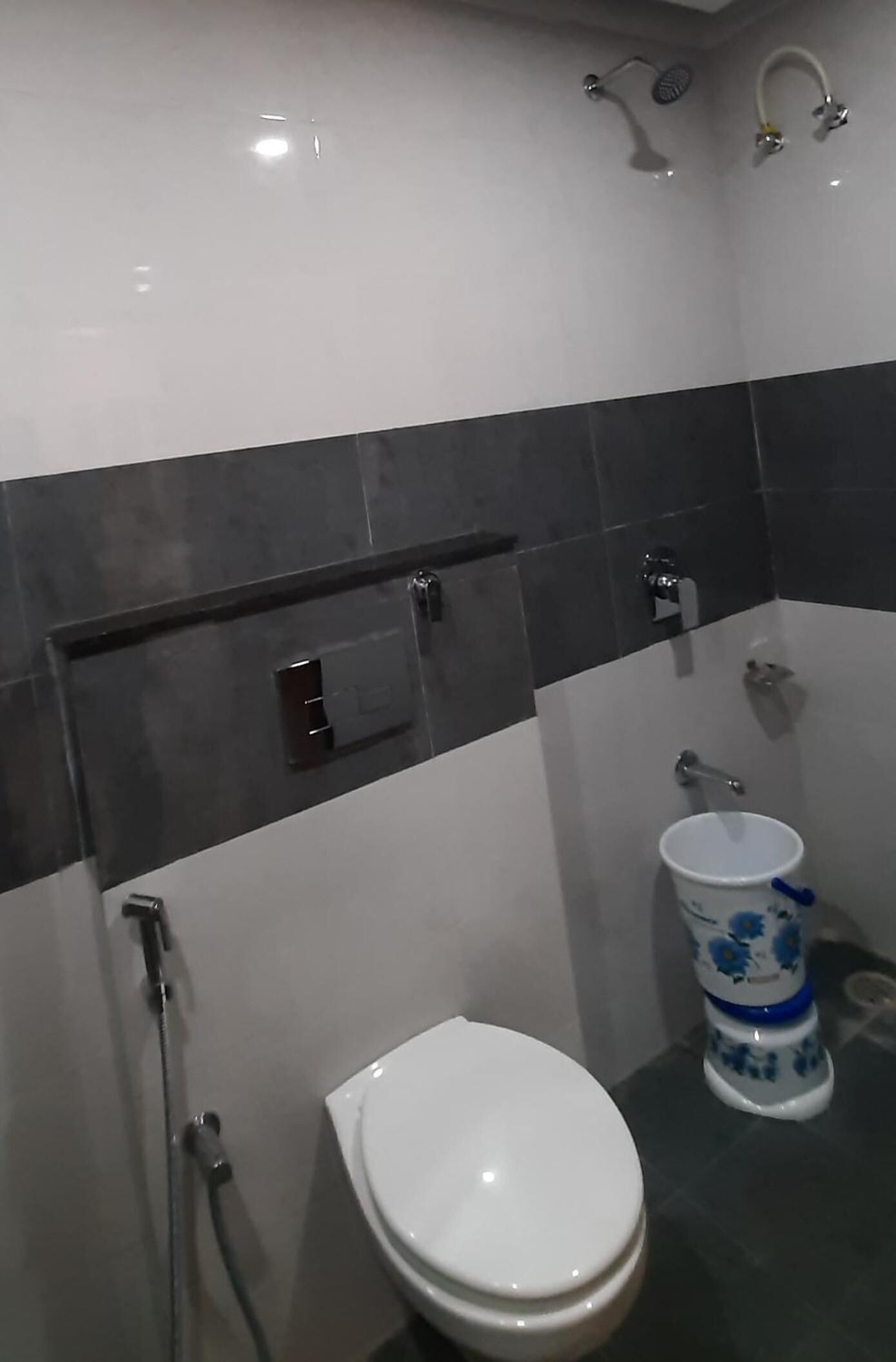 Een badkamer met een wit toilet, een douche en een bidet.