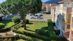 A residential area with a large tree, a parking lot, and multi-story buildings. - Air-conditioned apartment. Close to shops and sea. Parking. Rated Atout France 1*. (Argelès-sur-Mer)