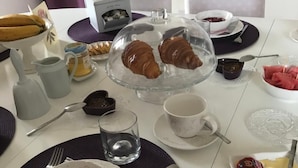 A breakfast setting with croissants, yogurt with berries, and a glass of water. - Chambre d'Hôte Pivoine (Fralignes)