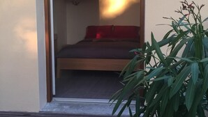 A room with a bed, a red pillow, and a potted plant. - Chambre d'Hôte Pivoine (Fralignes)